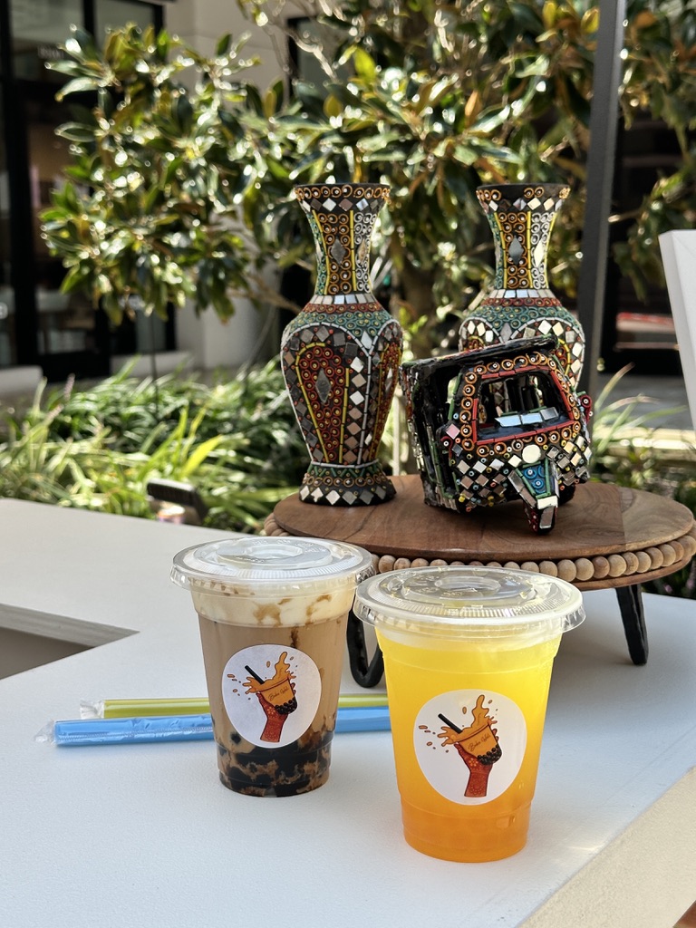 Colorful drinks displayed alongside floral vases